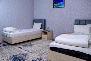 Fotih Hotel في Sergeli: غرفه سريرين وموقف ليلي فيها