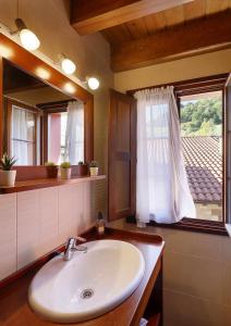 a bathroom with a sink and a mirror and a window at Casa Celis 1 Espinaredo in Espinaredo