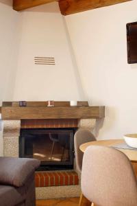 a living room with a fireplace with a table and chairs at Casa Celis 1 in Espinaredo +21 photos