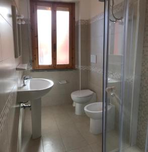 a bathroom with a toilet and a sink and a shower at Appartamenti Campeggio del Forte in Marina di Bibbona