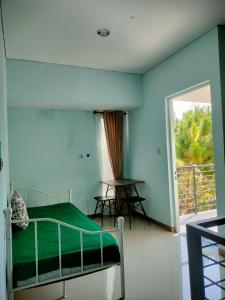 ein Schlafzimmer mit einem Bett und einem großen Fenster in der Unterkunft Alana Family Vila in Garut