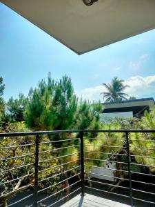 uma varanda com vista para uma palmeira em Alana Family Vila em Garut