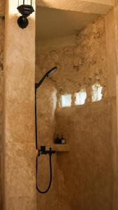 a bathroom with a shower in a stone wall at Ulunia in Uluwatu