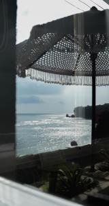 a view of the ocean through a glass window at Ulunia in Uluwatu