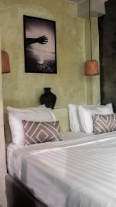 a bedroom with a bed with white sheets and pillows at Ulunia in Uluwatu