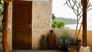 an open door with vases sitting next to a window at Ulunia in Uluwatu