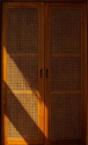a wooden cabinet with a door with a metal screen at Ulunia in Uluwatu