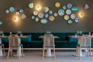 um restaurante com duas mesas e um sofá verde em Hilton Garden Inn Marseille Provence Airport em Marignane