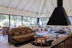 a living room with a couch and tables and chairs at Hilton Garden Inn Marseille Provence Airport in Marignane