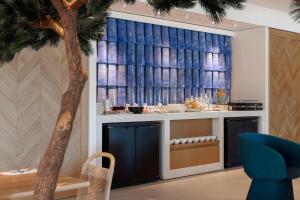 a living room with a palm tree and a table at Hilton Garden Inn Marseille Provence Airport in Marignane