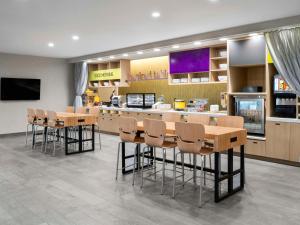 a restaurant with tables and chairs and a counter at Home2 Suites by Hilton Orlando South Davenport in Davenport