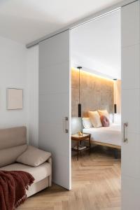 1 dormitorio con cama, sofá y mesa en Magno Apartments Zaragoza, en Sevilla