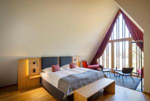 um quarto com uma cama e uma grande janela em JUFA Hotel Bregenz em Bregenz