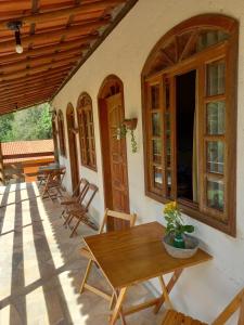 um pátio com uma mesa de madeira e cadeiras em Cipó Hostel em Serra do Cipó