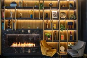 a lobby with a fireplace and two chairs at The Major Hotel in Rome