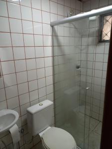 uma casa de banho com um WC e uma cabina de duche em vidro. em Cipó Hostel em Serra do Cipó