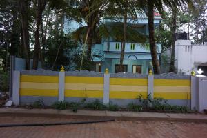a yellow and white fence in front of a house at VPR Cottage in Yelagiri