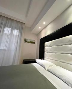 a bedroom with a large bed with a large headboard at Il Paradiso di Dante in Naples