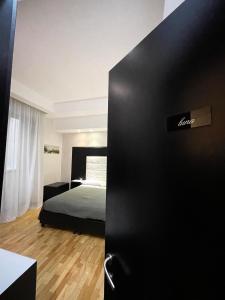 a bedroom with a bed and a black door at Il Paradiso di Dante in Naples