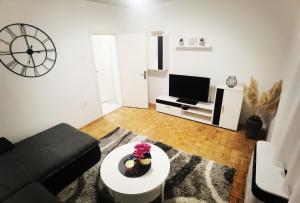 ein Wohnzimmer mit einem Sofa und einem TV in der Unterkunft Privatni Smještaj Harmony in Osijek