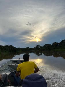 un hombre montando en un barco en un río en PANTANAL SANTA CLARA, en Corumbá