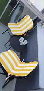 duas cadeiras amarelas e brancas ao lado de um edifício em City center apartment em Pieksamaki