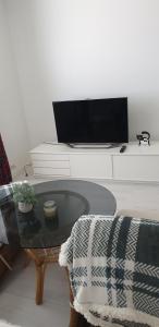 a living room with a glass table and a tv at City center apartment in Pieksamaki
