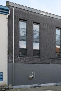 a large brick building with a garage door at Spacious & Chic House in Center in Kortrijk