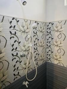 a shower in a bathroom with flowers on the wall at Black Panther Yala in Tissamaharama