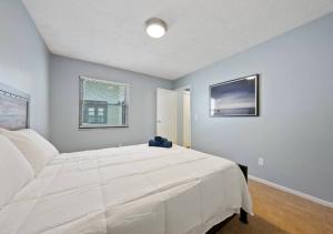 a bedroom with a large white bed and two windows at Modern 3 Bed Apartment At Mid West in New York