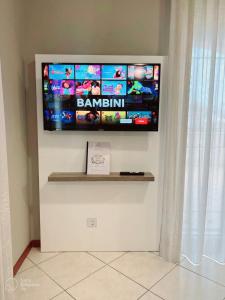 TV de pantalla plana colgada en la pared en Residenza Mediterranea Apartments, en Rímini