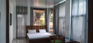 Kleines Zimmer mit einem Bett und einem Fenster in der Unterkunft Hotel RAJVIHAR in Pachmarhi
