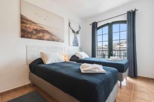 dwa łóżka w pokoju z oknem w obiekcie Residencial Las Candelarias 34 w mieście Agaete