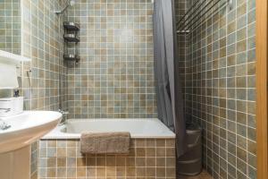 een badkamer met een bad en een wastafel bij Residencial Las Candelarias 34 in Agaete