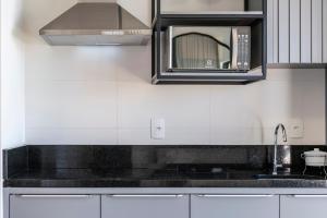 una cocina con fregadero y microondas en HY Apart, en Bombinhas 100 fotos más