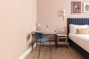 einen kleinen Schreibtisch mit einem blauen Stuhl neben einem Bett in der Unterkunft numa I Linea in Rom