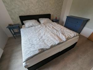 a bedroom with a bed with a blue dresser and two tables at Burg Stargard Zwei Zimmer Wohnung in Burg Stargard