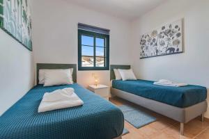 1 Schlafzimmer mit 2 Betten und einem Fenster in der Unterkunft Residencial Las Candelarias 36 in Agaete