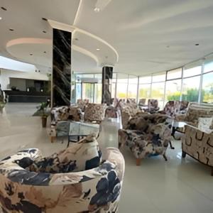 a room with couches and chairs in a building at AFYTOS ÖREN BEACH PRESTİJ in Burhaniye