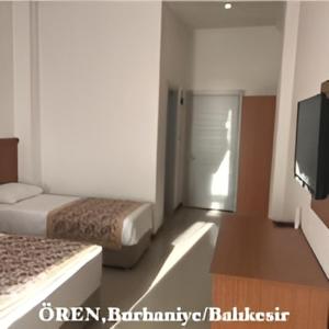 a room with two beds and a flat screen tv at AFYTOS ÖREN BEACH PRESTİJ in Burhaniye