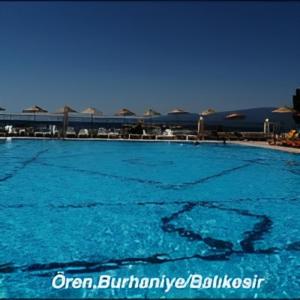 a large swimming pool with blue water at AFYTOS ÖREN BEACH PRESTİJ in Burhaniye