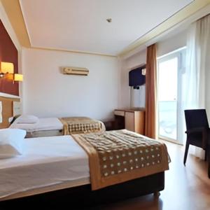 a hotel room with a bed and a window at AFYTOS ÖREN BEACH PRESTİJ in Burhaniye +50 photos
