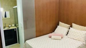 Dormitorio con cama con almohada rosa en Farol da Barra express - suítes, en Salvador