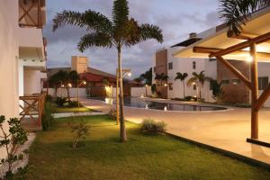 a courtyard with a palm tree and a swimming pool at Vila do Mar - Macapá in Luis Correia