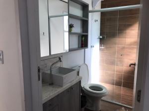 a bathroom with a white sink and a toilet at Apt- Suíte - Quadra mar - Aeroporto/Beto Carreiro in Navegantes +9 photos