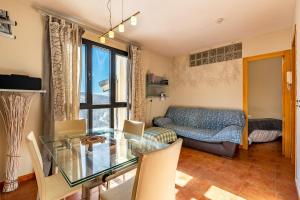 ein Wohnzimmer mit einem Glastisch und einem Sofa in der Unterkunft Apartamento diseño a pie de pista in Monachil