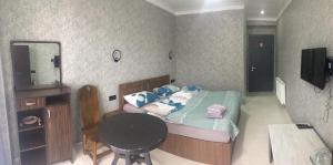 a bedroom with a bed with a table and a mirror at House by the Sea in Kobuleti