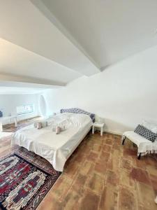 1 dormitorio con 1 cama, 1 silla y 1 alfombra en L'écrin Lauragais - Grande maison, 3 chambres 3sdb en Villefranche-de-Lauragais
