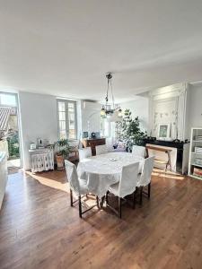 ein Esszimmer mit einem Tisch und weißen Stühlen in der Unterkunft L'écrin Lauragais - Grande maison, 3 chambres 3sdb in Villefranche-de-Lauragais