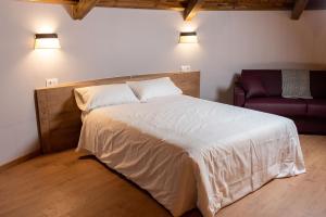 ein Schlafzimmer mit großem Bett und Couch in der Unterkunft Pallozas Turísticas Ridicodias - A Vieira in Laza